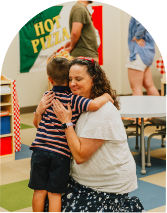 teacher hugging a little boy